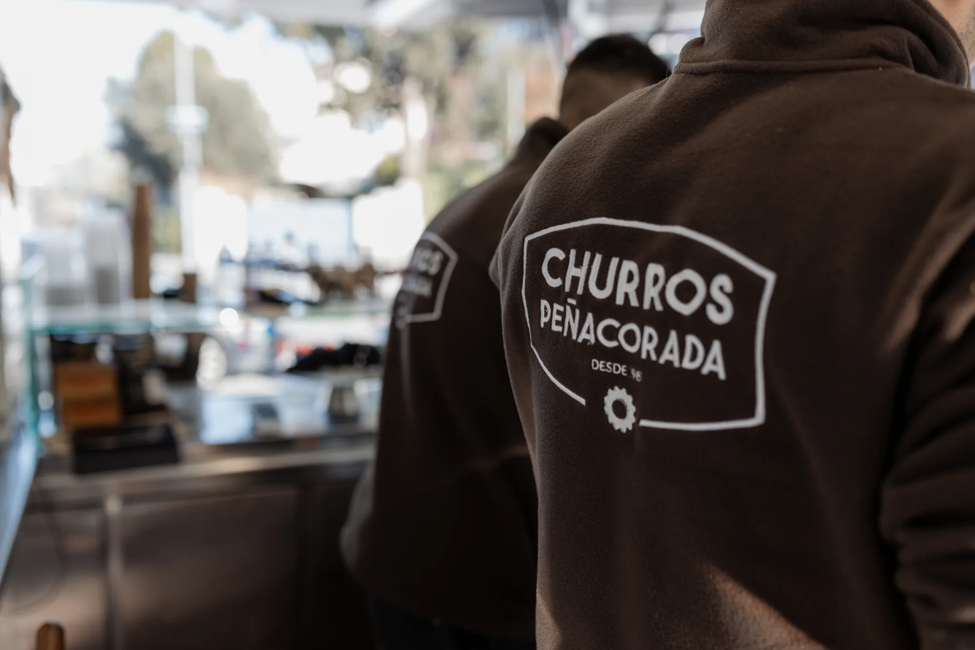 El equipo con las sudaderas de Churros Peñacorada dentro del food truck